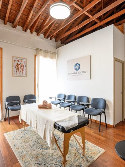 Aula de quiromasaje de Harmony Academy en Málaga, con camilla y sillas de pala para los alumnos