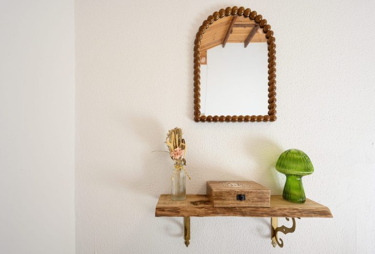Detalle decorativo de la cabina de prácticas: espejo y estante de madera