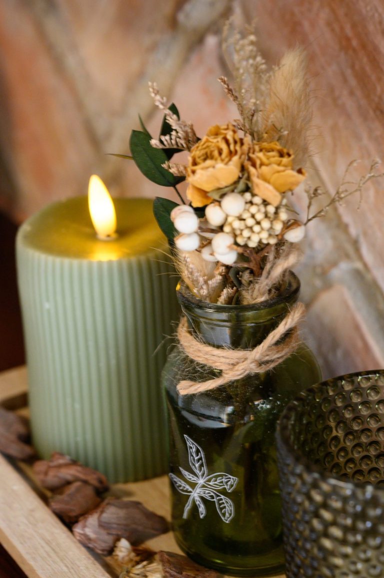 Detalle decorativo: vela y flores secas en el aula
